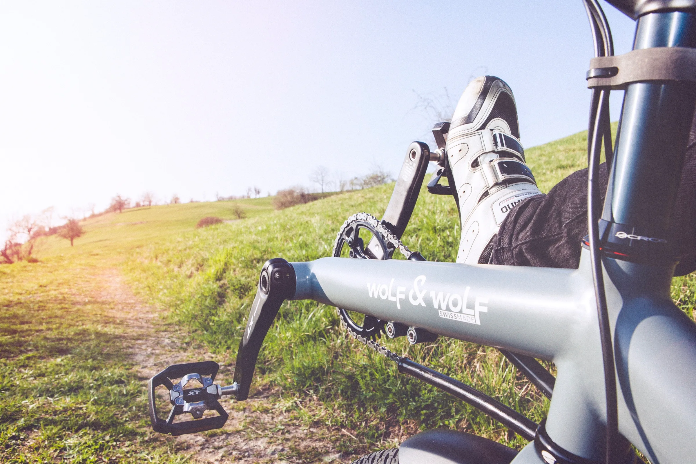 Kurbel und Pedal eines Alpentourers im Gras